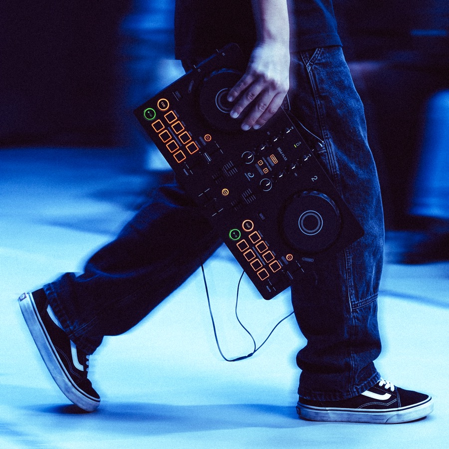 An instructor working one to one with a student at a DJ controller